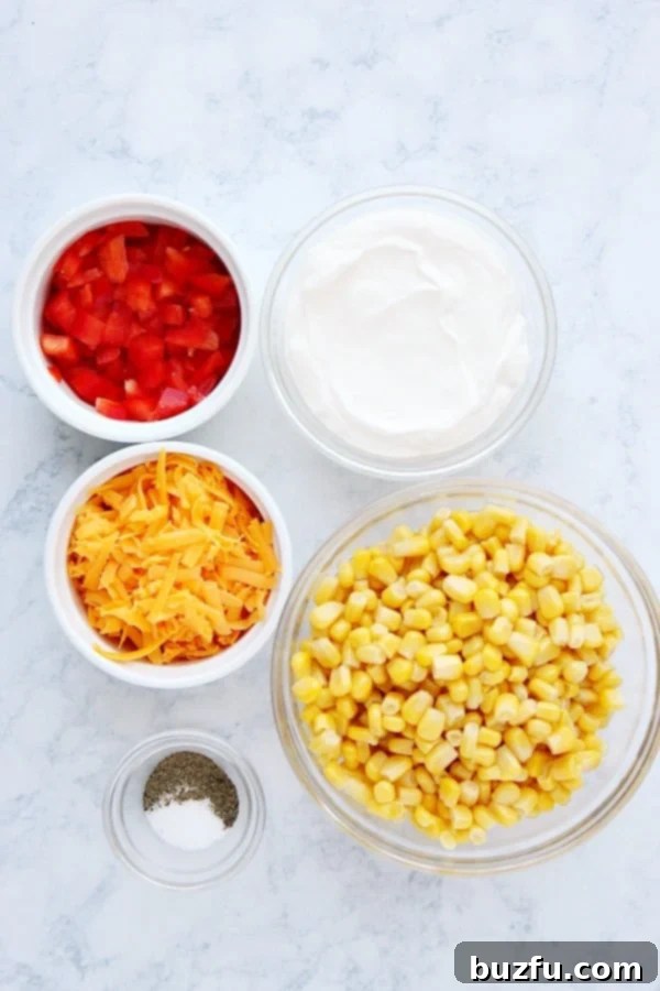 What do you need to make Creamy Corn Dip. All the fresh and creamy ingredients for a delicious corn dip laid out on a marble surface.