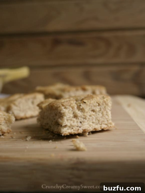 A slice of freshly baked whole wheat focaccia on a cutting board, showing its soft interior.