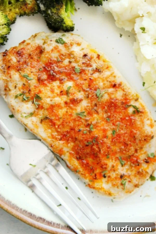 Herb-Crusted Baked Pork Chops 2 Perfectly baked boneless pork chops served on a white plate with roasted vegetables.