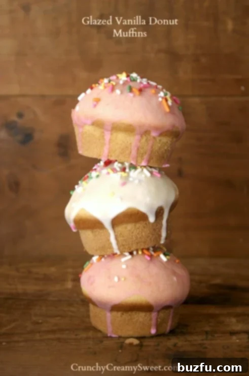 Glazed Vanilla Donut Muffins | CrunchyCreamySweet.com Irresistible Glazed Vanilla Donut Muffins, freshly baked and adorned with a sweet vanilla glaze and colorful sprinkles, resting on a wire rack.
