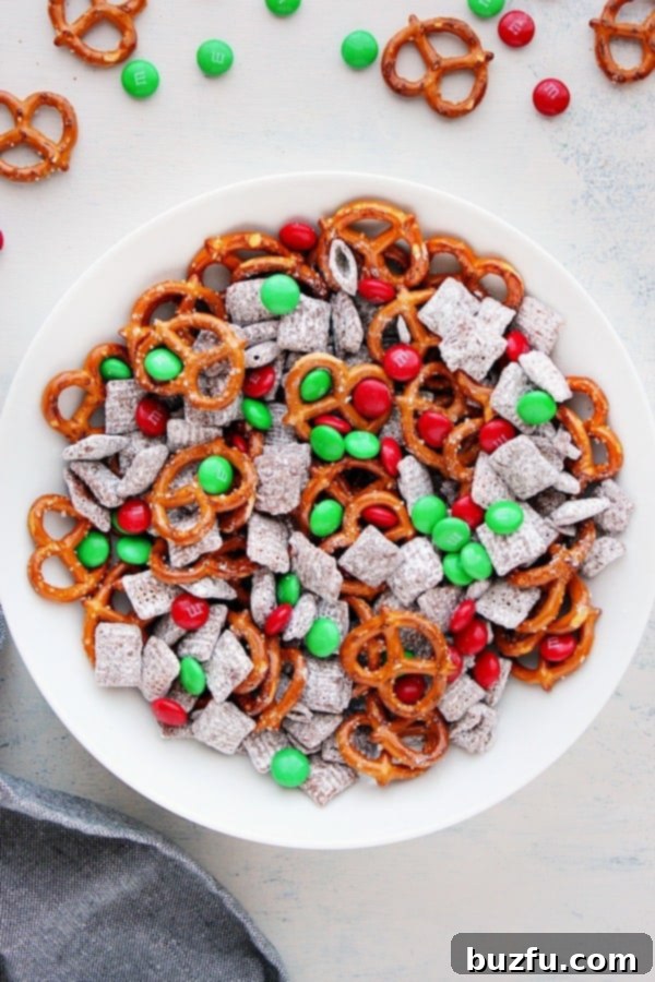 Christmas cereal mix in a bowl with M&M's and pretzels.