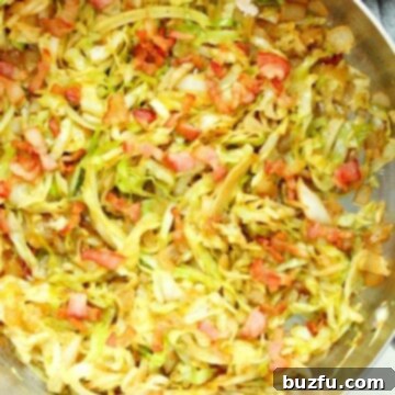 Fried Cabbage in a skillet, close-up shot showing texture and ingredients.
