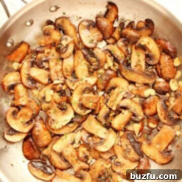 Sauteed Mushrooms in a pan, ready to be served, glowing with garlic butter.
