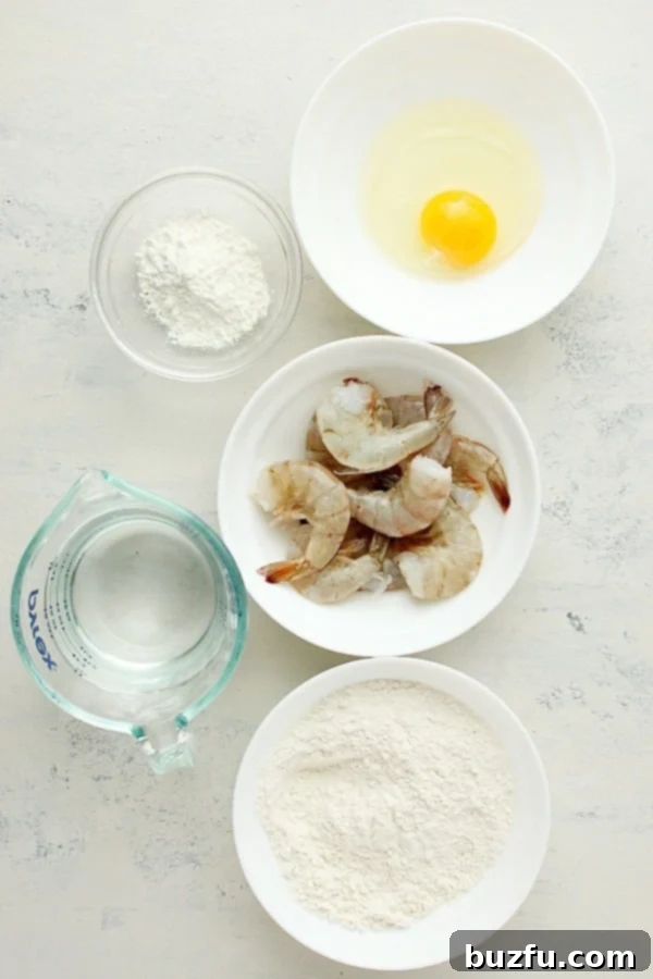 Shrimp, flour, egg and water on a white board, ready for making tempura.