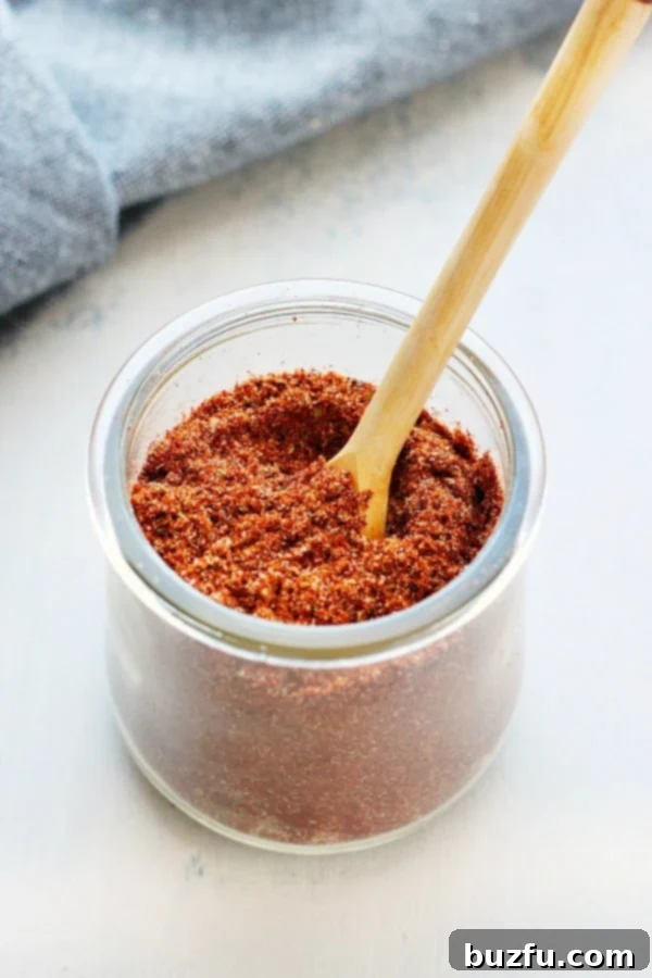 Homemade Taco Seasoning Taco seasoning in a beautiful glass jar, ready for use, against a rustic backdrop.
