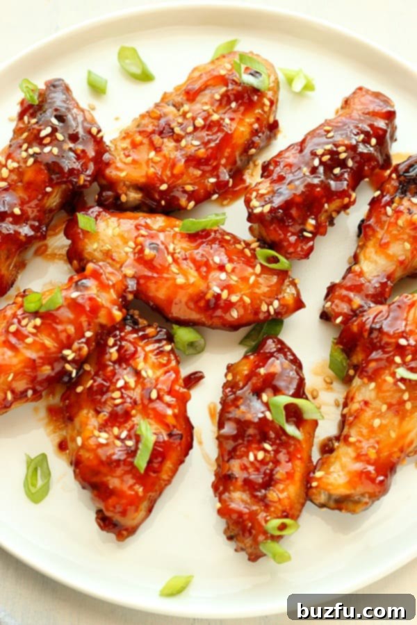 Asian chicken wings on a white round plate.