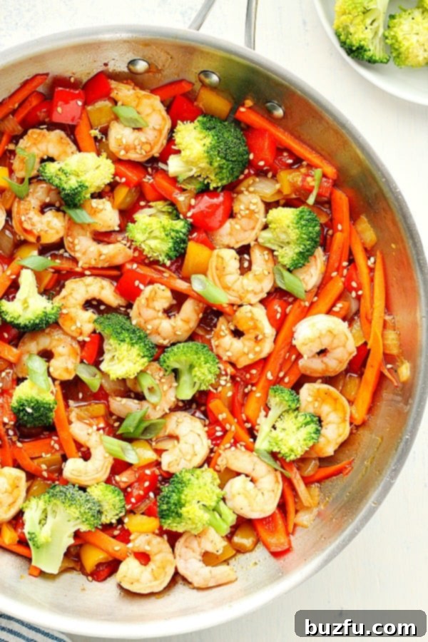 This easy Shrimp Stir Fry recipe is made with fresh shrimp, veggie mix and stir fry sauce, all done in 15 minutes. Shrimp Stir Fry in a skillet.
