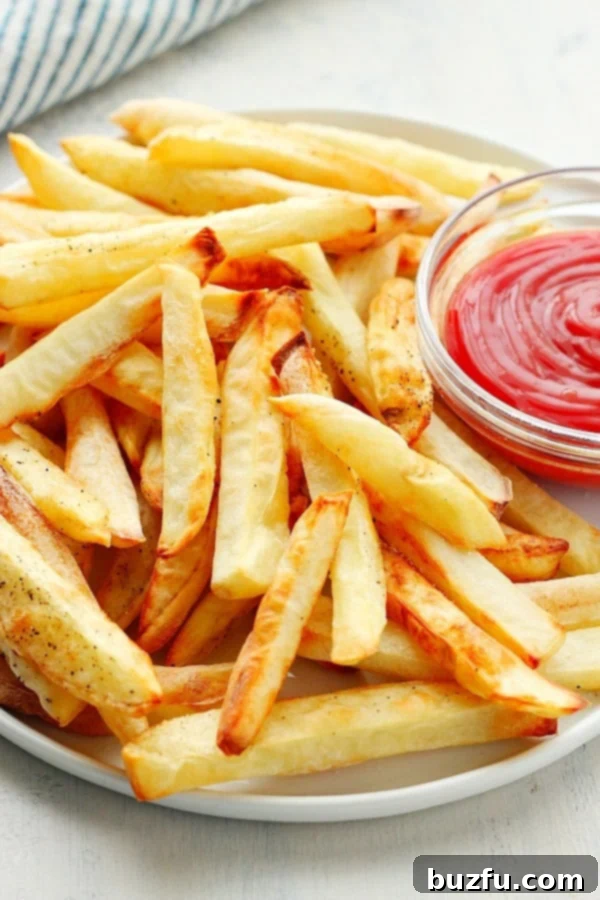 Crispy, golden Air Fryer French Fries perfectly cooked and served on a plate.