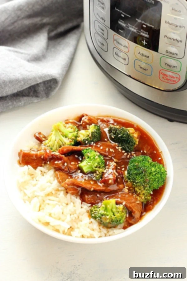 A serving of Instant Pot Beef and Broccoli in a white bowl, with the Instant Pot in the background.