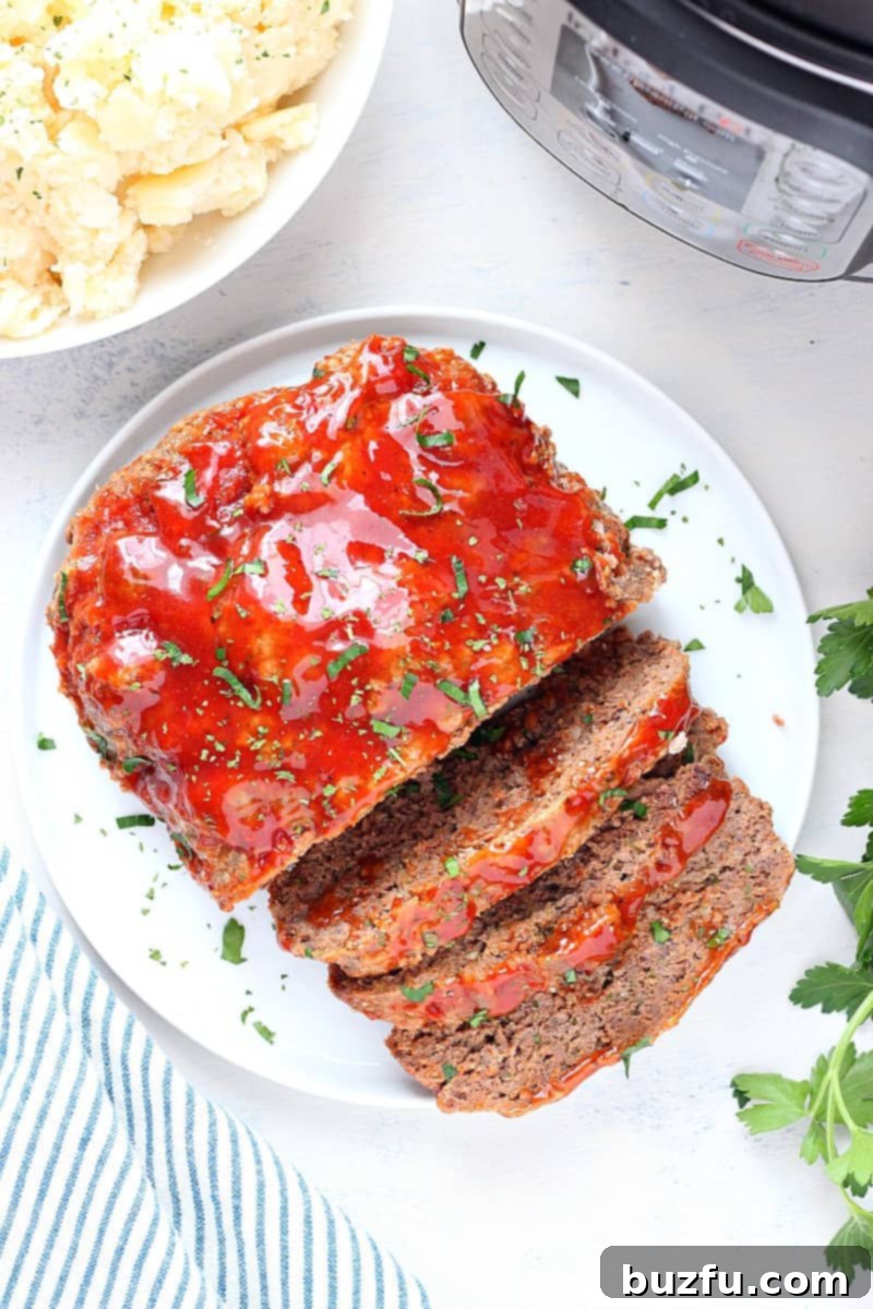 Best pressure cooker meatloaf with potatoes. Beef meatloaf on a plate next to pressure cooker.