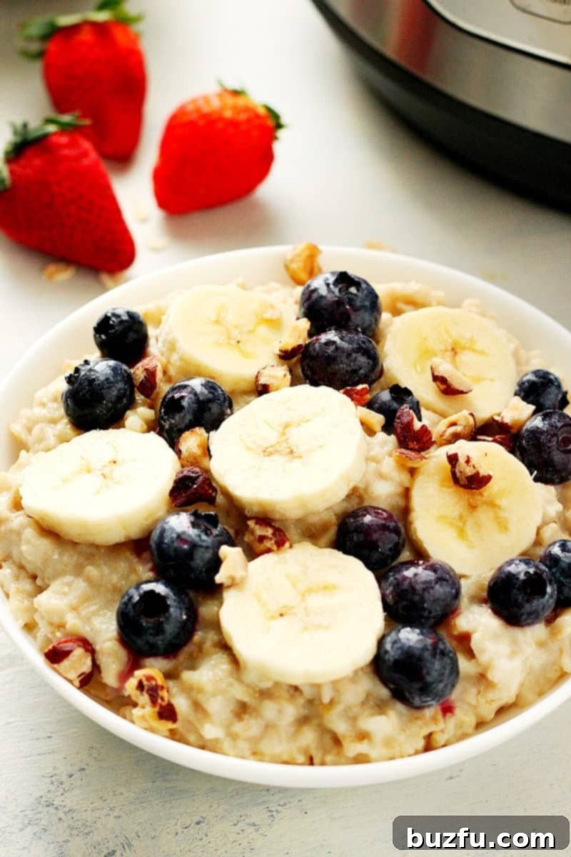 Instant Pot oatmeal with bananas and berries in a white bowl.