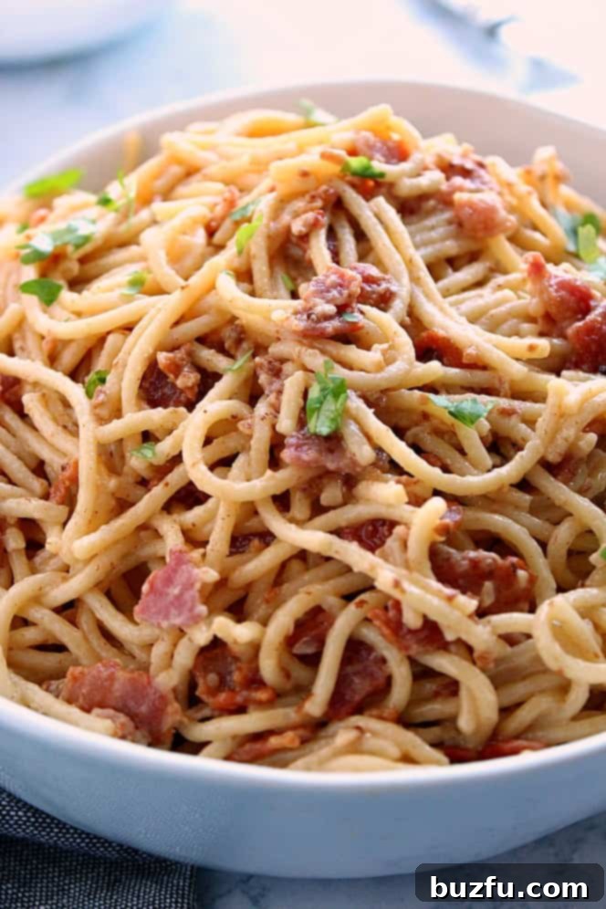Delicious and easy Instant Pot Pasta Carbonara made with spaghetti, crispy bacon, aromatic garlic, and rich Parmesan cheese, served in a bowl.