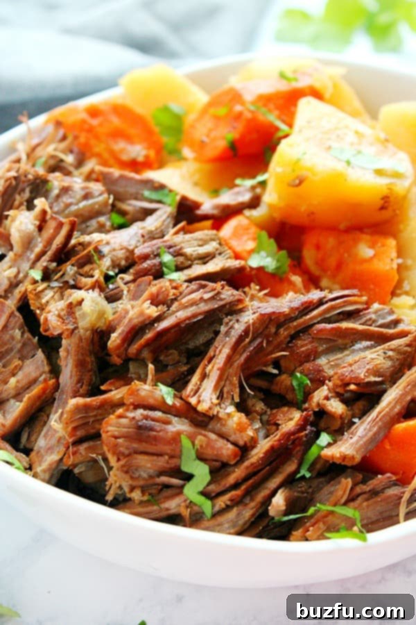 Hearty Instant Pot Pot Roast with tender potatoes and carrots, generously portioned on a rustic plate.