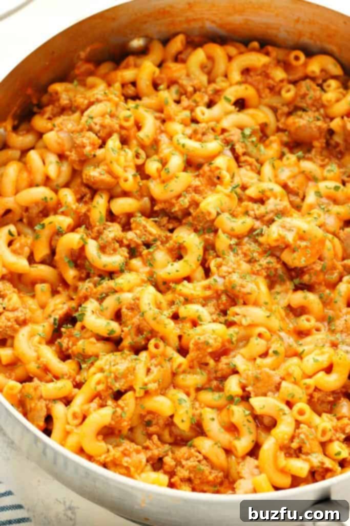 A savory homemade macaroni and beef casserole in a stainless steel skillet, ready to be served.