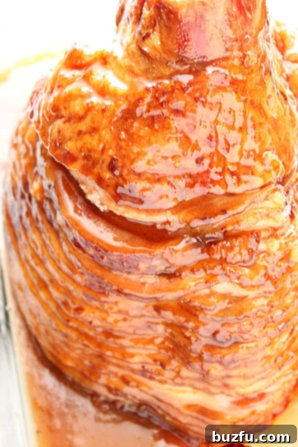 Glazed ham in a baking dish, fresh from the oven and bubbling.
