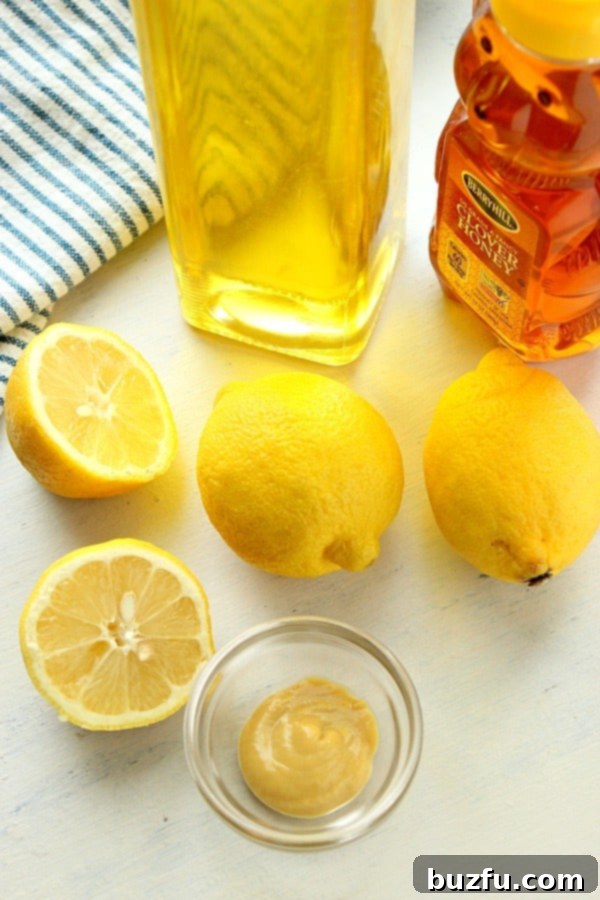 Bright Lemon Vinaigrette 3 Lemons, oil and honey on a white board.