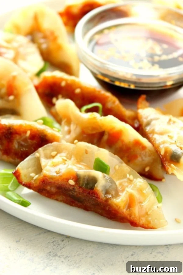 A plate piled high with golden-brown, perfectly cooked vegetable potstickers, garnished with fresh herbs, ready to be enjoyed.