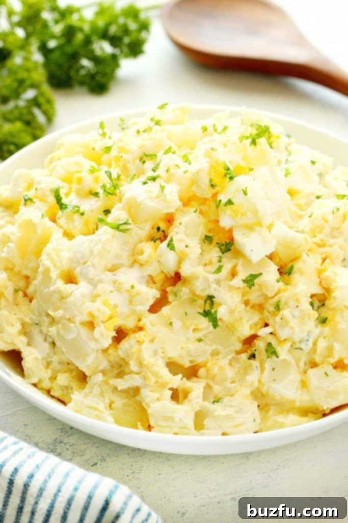 Best Instant Pot Potato Salad Recipe Classic Instant Pot Potato Salad served in a large white bowl, garnished with fresh herbs, ready to be enjoyed.