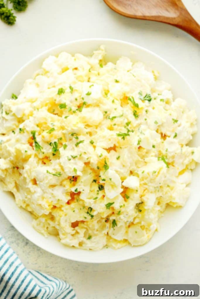 Perfectly Creamy Instant Pot Potato Salad for Any Occasion A close-up shot of creamy, perfectly textured potato salad in a clean white bowl, highlighting its appetizing appearance.