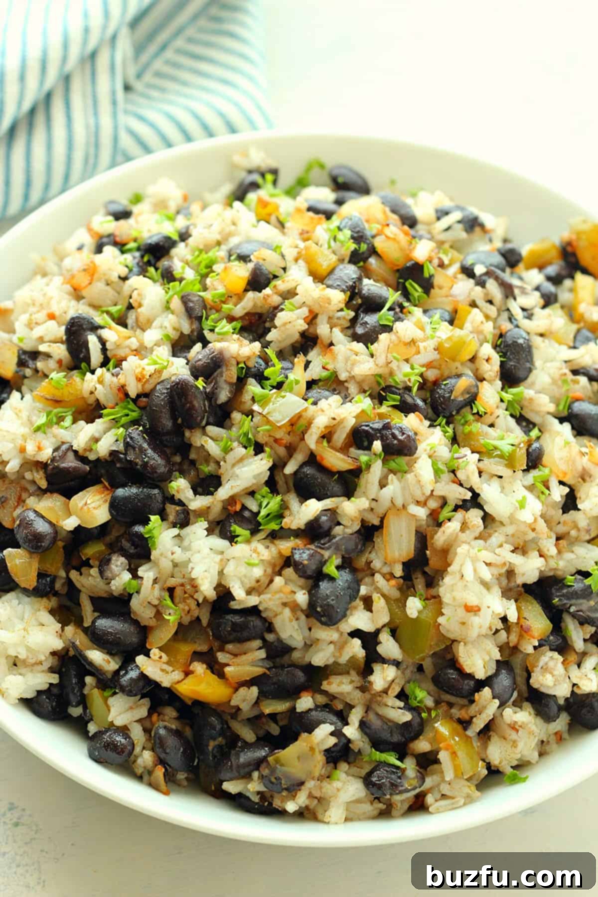 A vibrant bowl of Black Beans and Rice, garnished with fresh herbs, ready to be enjoyed.