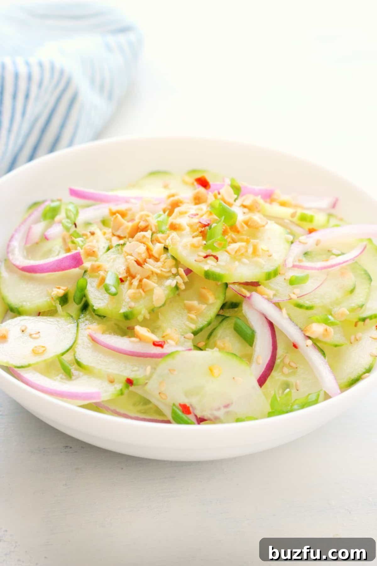Cucumber salad in a white bowl.