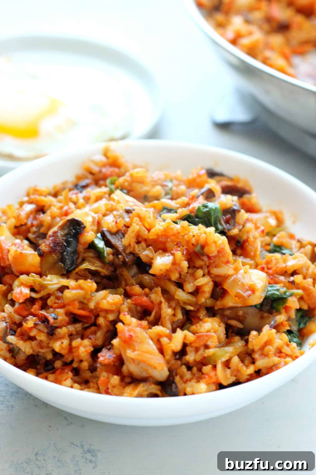 Easy Kimchi Fried Rice Cooked rice with kimchi in a bowl. A close-up of the finished Kimchi Fried Rice in a rustic bowl, ready to be enjoyed.