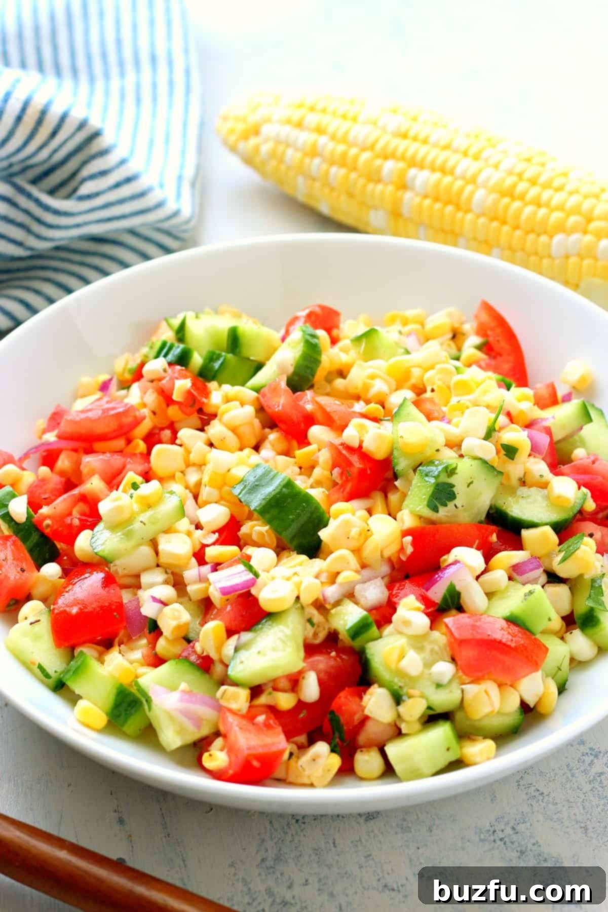 Corn, tomatoes and cucumber in a bowl.