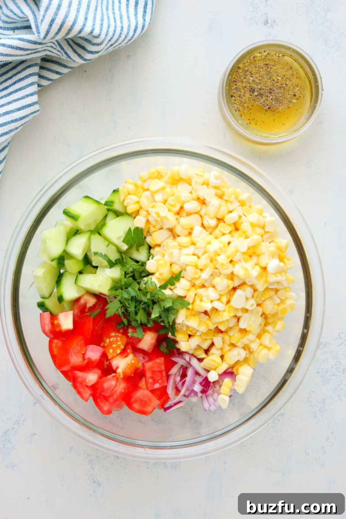 Ingredients for corn salad in a glass bowl.