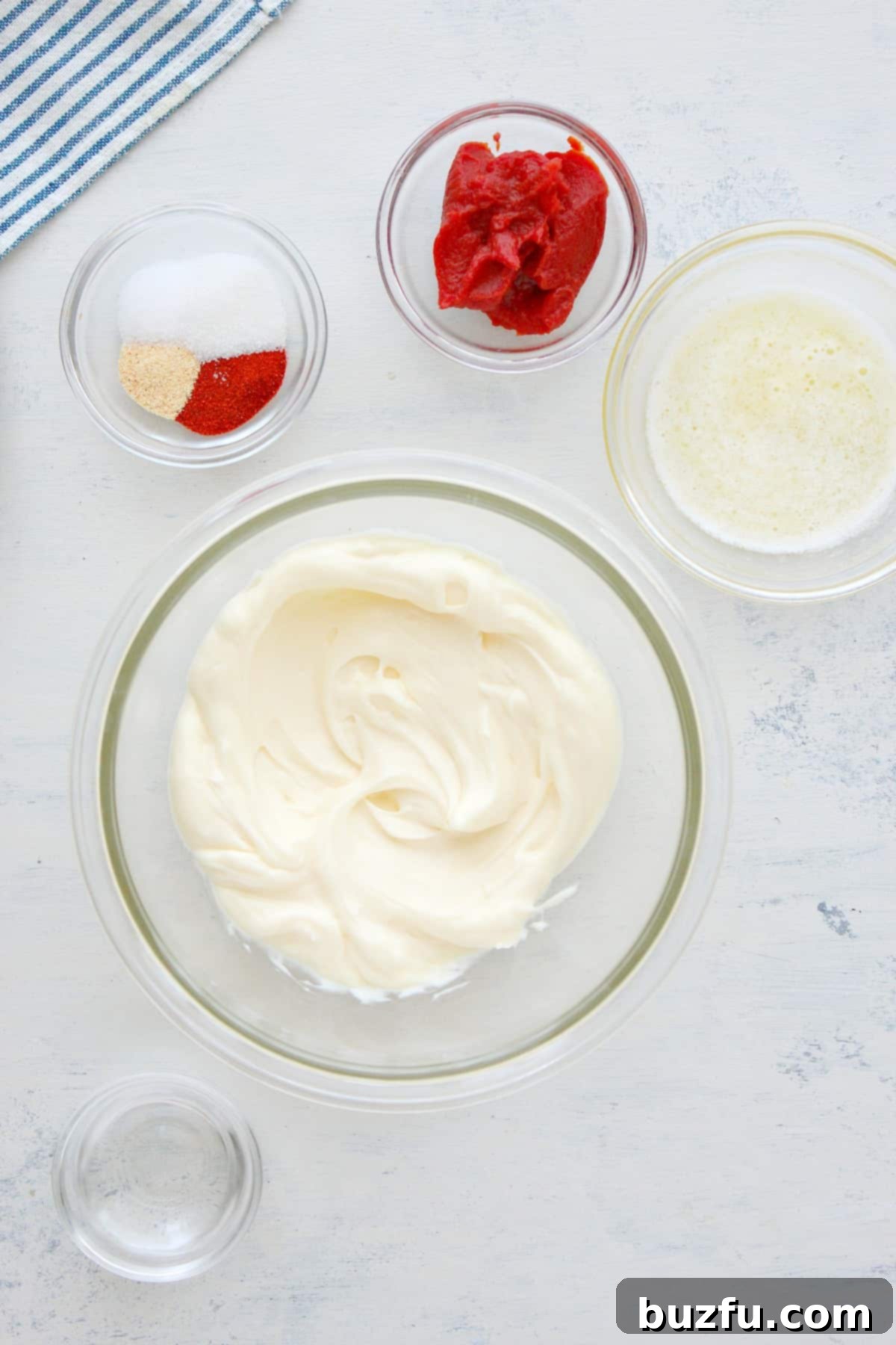 Yum Yum Sauce Ingredients List Arrangement of fresh ingredients including mayonnaise, tomato paste, butter, and various spices on a white cutting board, showcasing the simple components of Yum Yum Sauce.