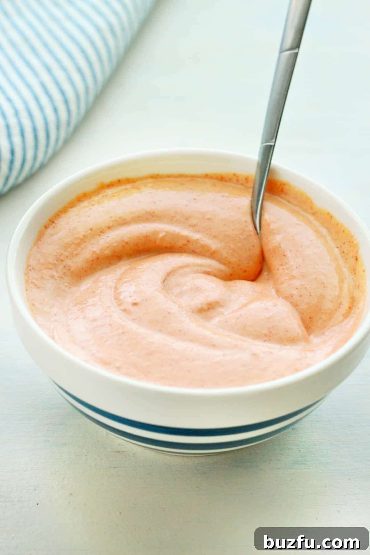 Versatile Japanese Hibachi Sauce Uses A bowl of rich, creamy Japanese hibachi sauce with a spoon, highlighting its inviting texture and readiness for serving.