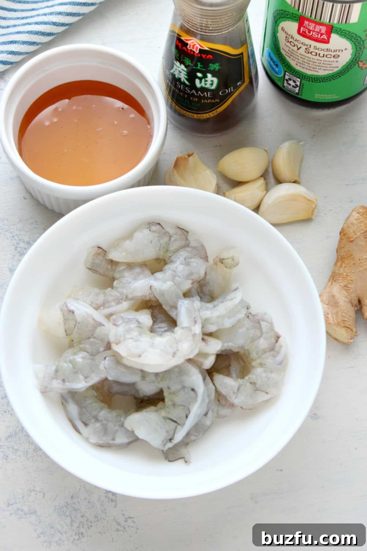 Ingredients in bowls on a board for honey garlic shrimp.