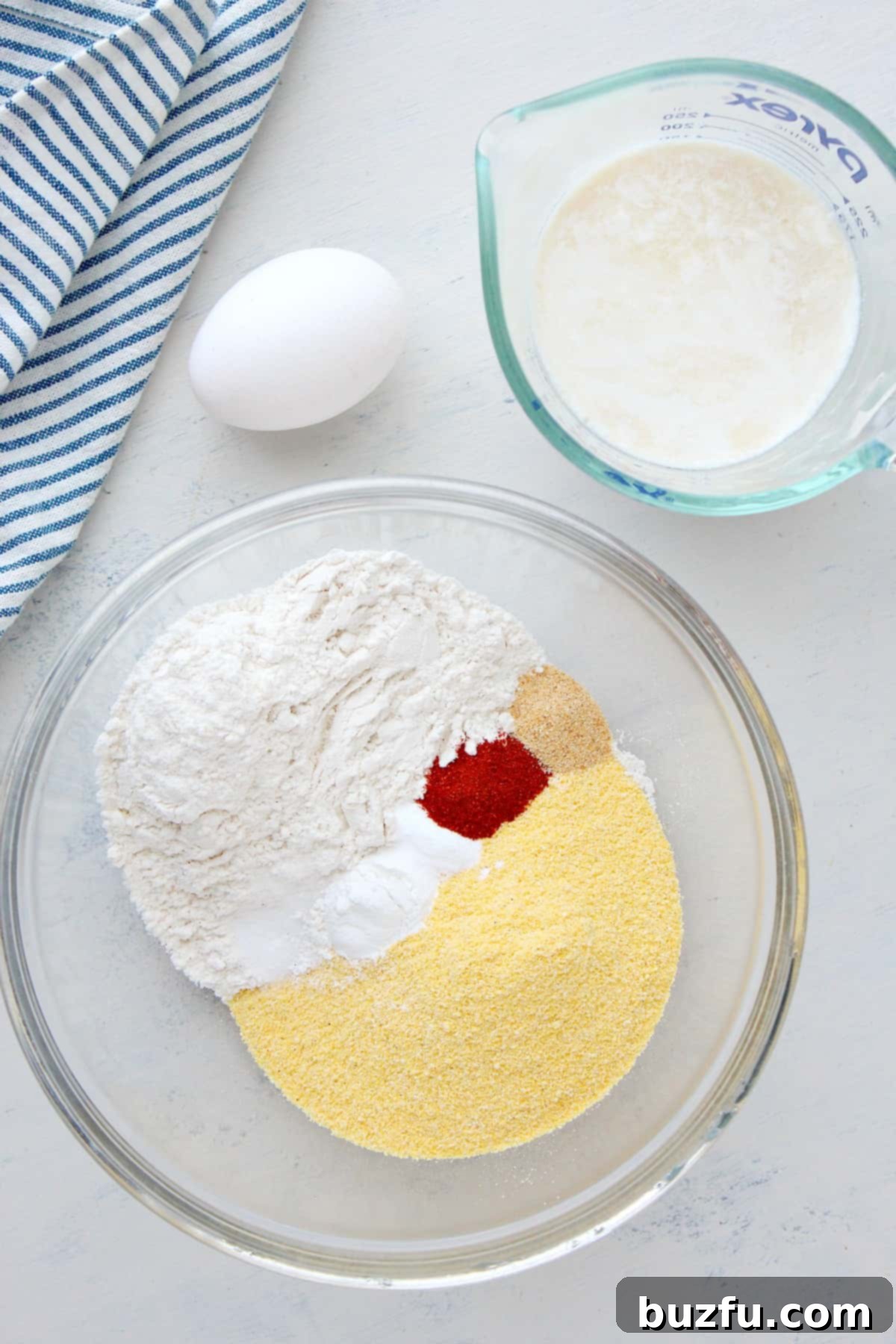 A collection of hush puppy ingredients laid out on a wooden board.