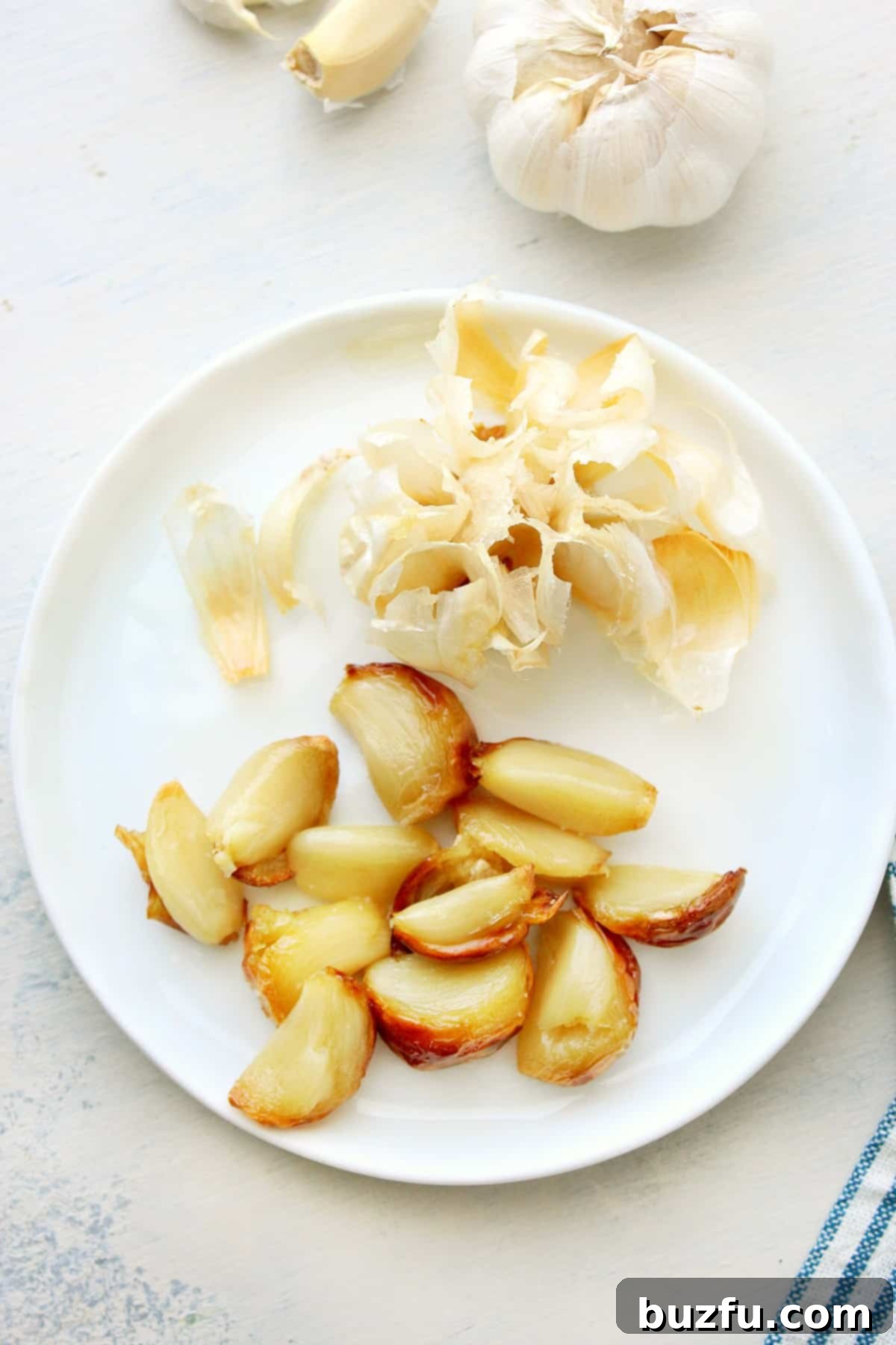 Perfectly roasted garlic cloves on a plate, ready to be mashed for aioli.