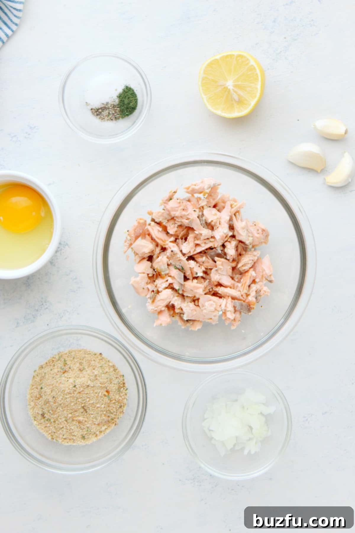 Salmon Patties ingredients for a delicious meal Ingredients for salmon patties laid out on a wooden cutting board.