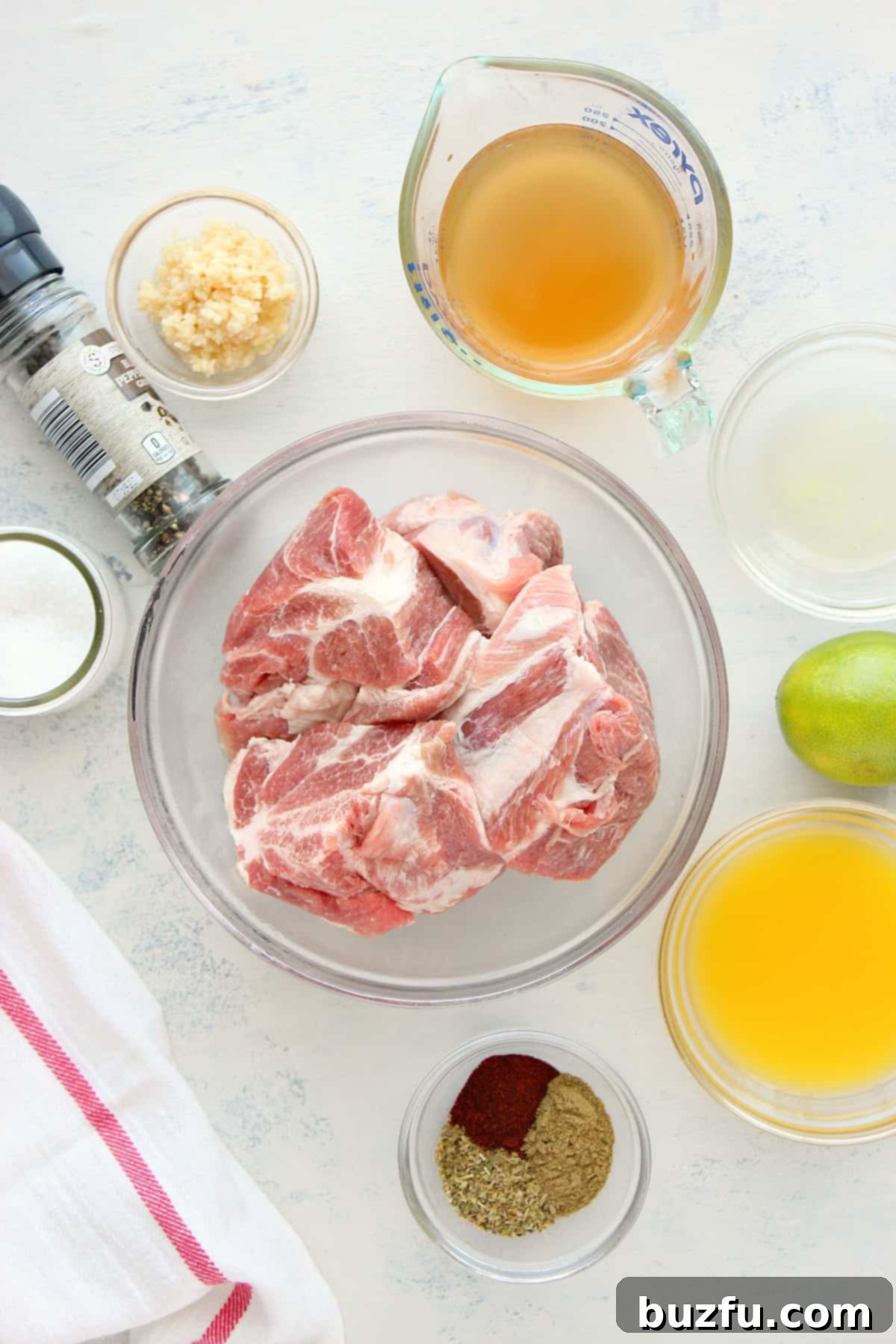 Instant Pot carnitas ingredients Ingredients for carnitas laid out on a white cutting board.
