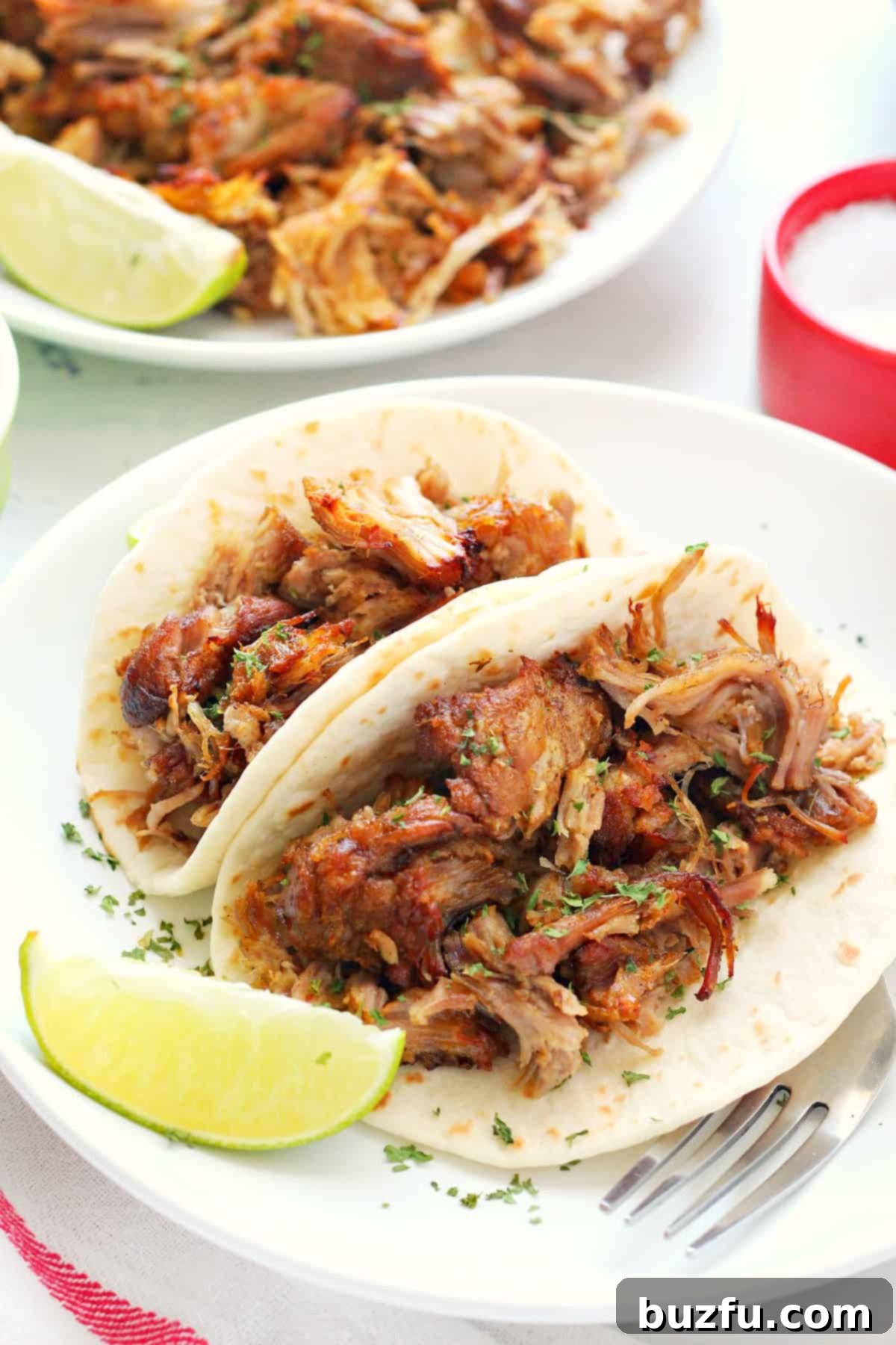 East Instant Pot Carnitas Pork carnitas served in small tortillas with cilantro and lime.
