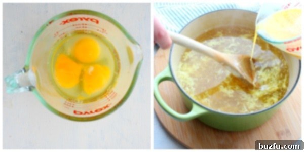 Pouring Beaten Eggs into Hot Stock Close-up shot of beaten eggs in a measuring cup, being slowly poured into a simmering pot of soup while stirring to create delicate egg ribbons.
