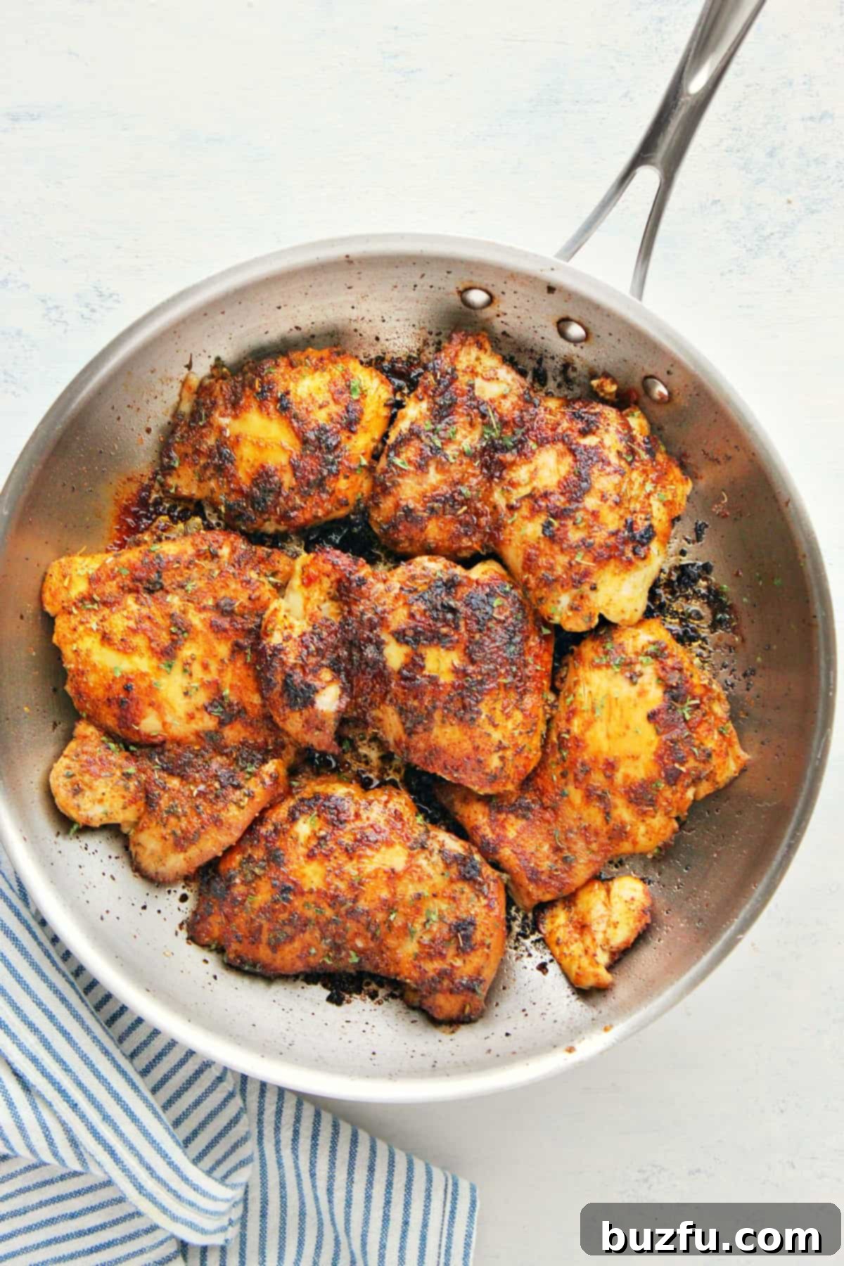 Stove Top Chicken Thighs recipe Chicken thighs searing in a hot skillet, creating a delicious crust.