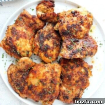 Golden Skillet Chicken 3 Cooked chicken thighs on a white plate.