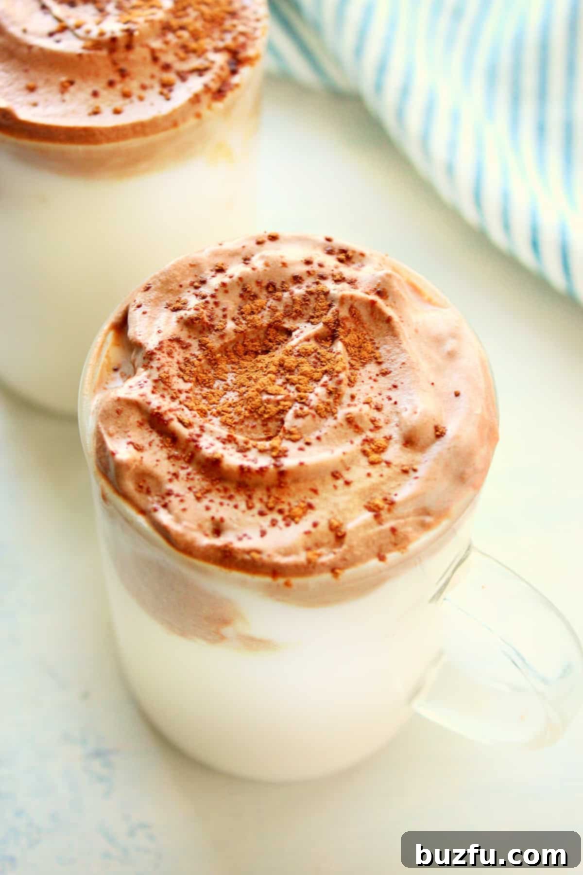 Whipped hot chocolate in a glass, topped with chocolate shavings.