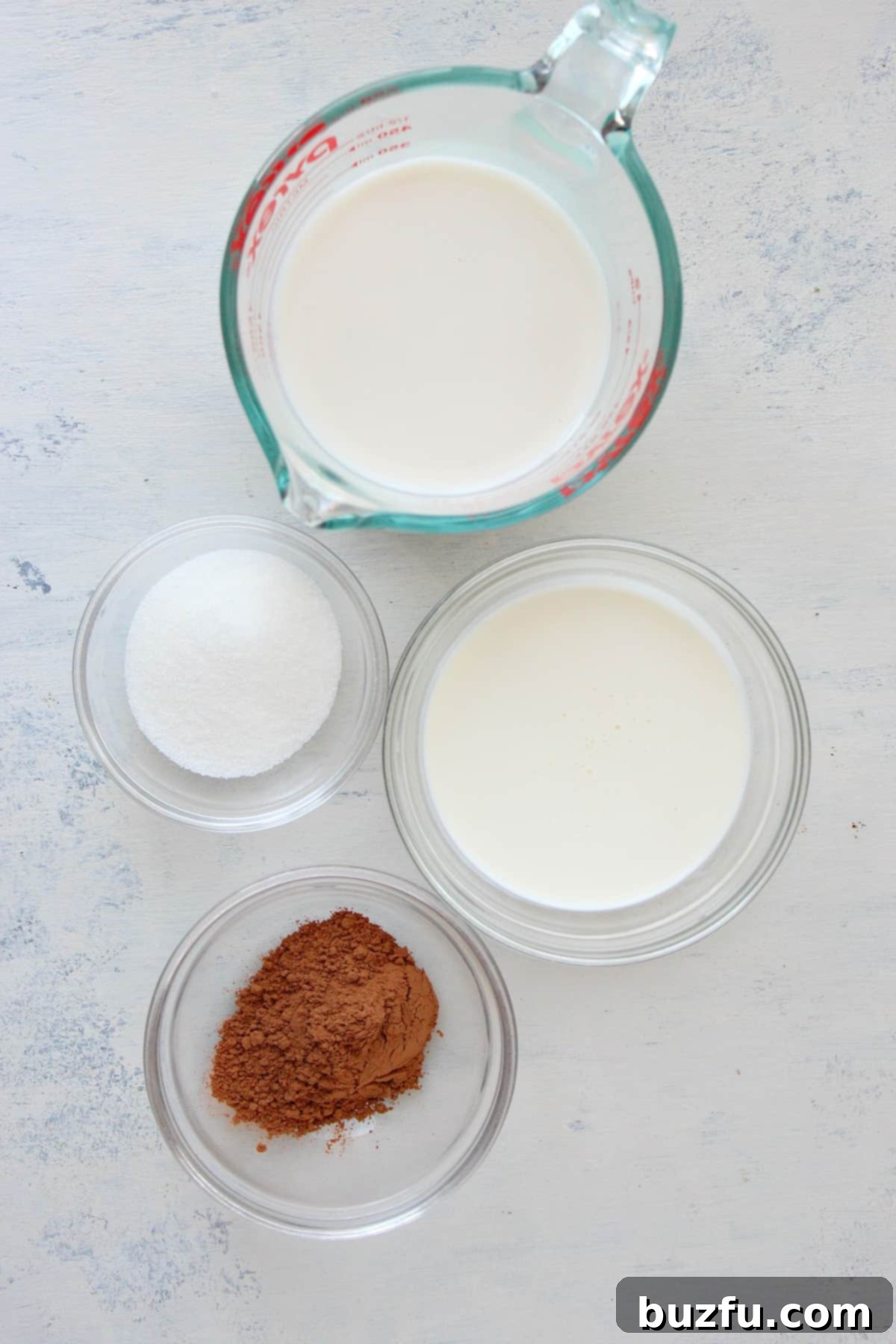 Ingredients for whipped hot chocolate laid out on a wooden board.