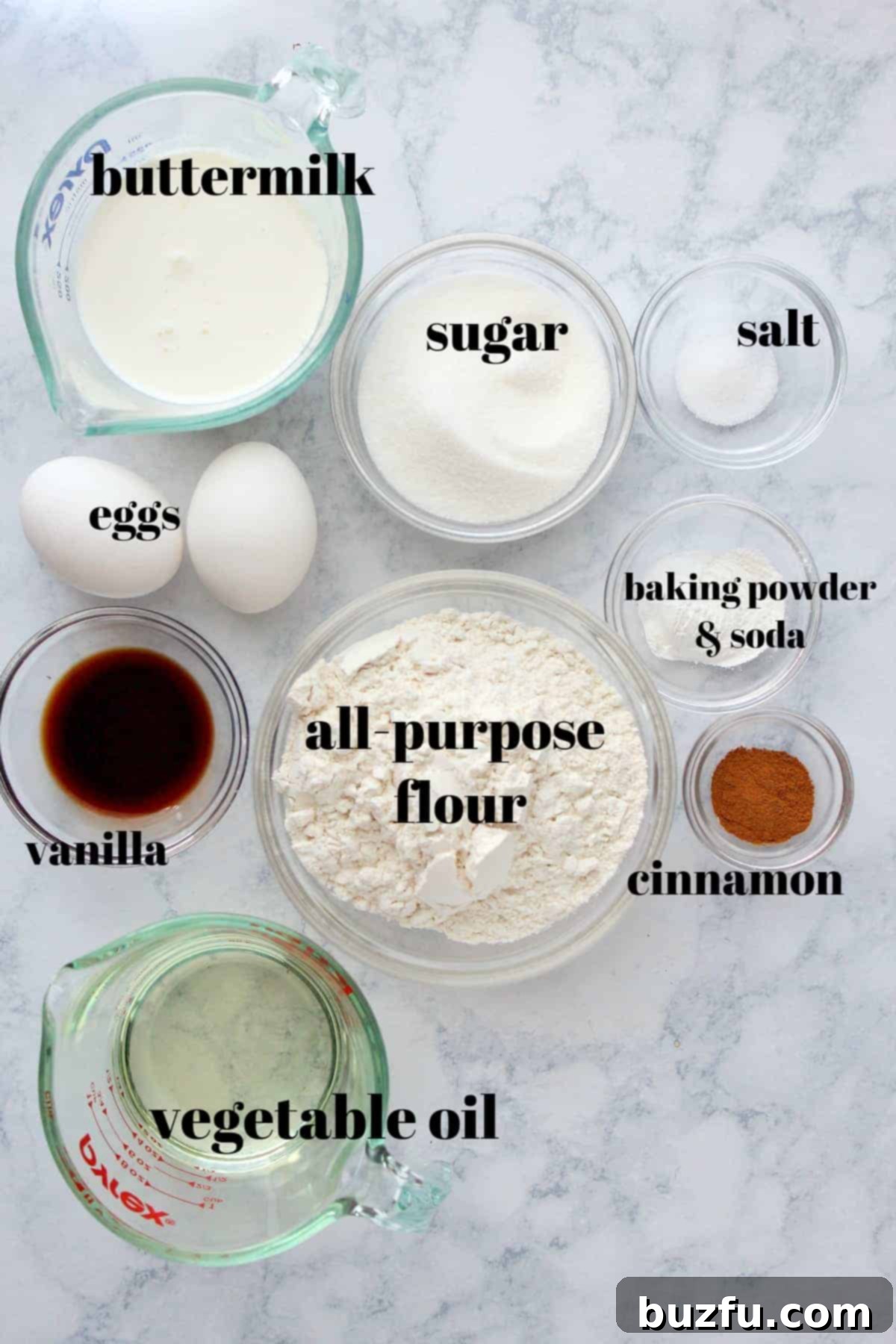 Effortless Crumble 2 Ingredients for crumb cake in glass bowls and cups, on a marble board.
