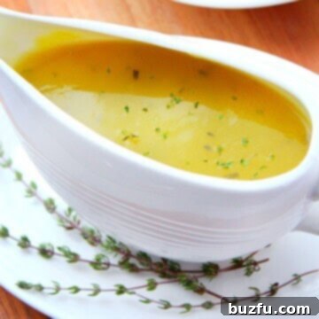 Creamy turkey gravy served in a pristine white gravy boat, highlighting its rich texture and inviting warmth.
