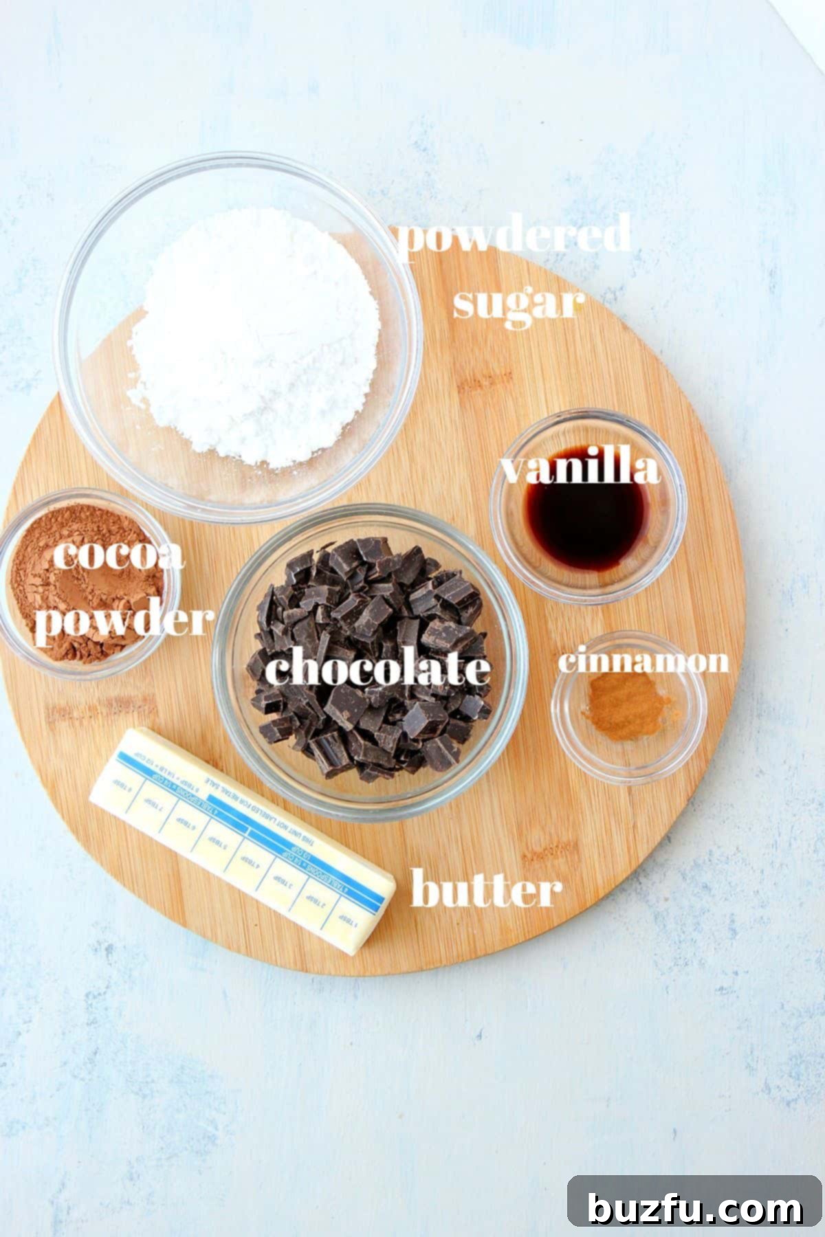 Finely chopped semi-sweet chocolate, powdered sugar, butter, cocoa powder, and vanilla extract for the babka filling, displayed on a wooden board.