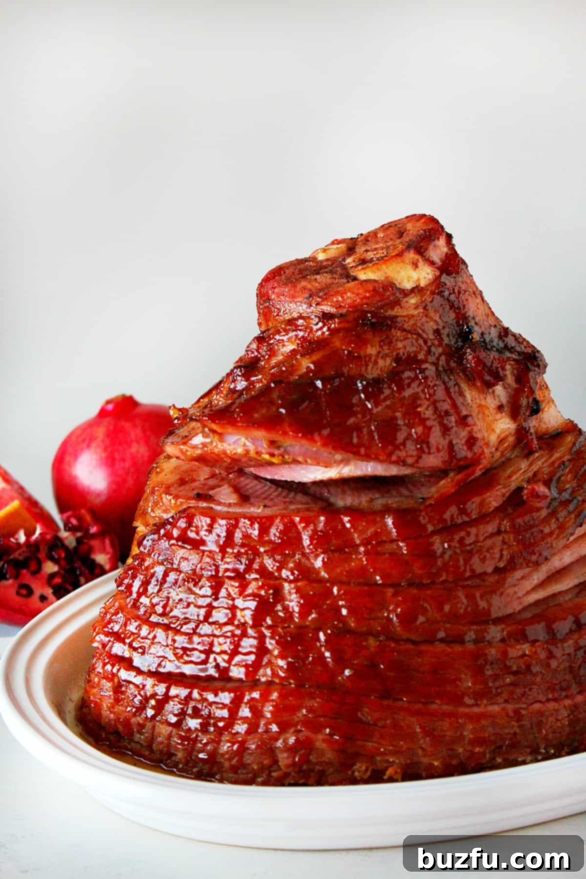 Christmas Ham recipe: Baked to perfection A perfectly baked Christmas ham, glistening with sweet glaze, presented on a pristine white platter, ready to be carved and enjoyed.