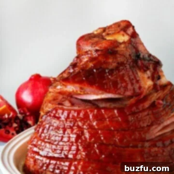 Showstopping Christmas Ham 3 Baked ham on a white platter, glistening with glaze.