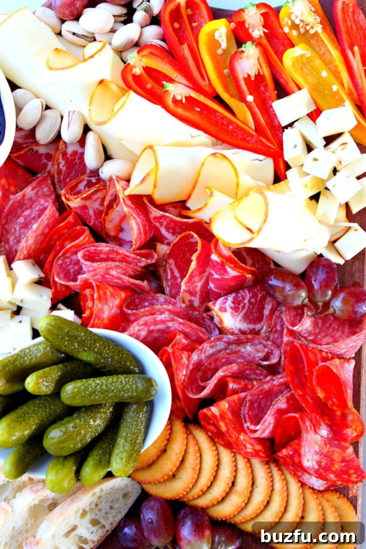 An easy-to-assemble cheese board brimming with a variety of meats, cheeses, fresh and dried fruits, nuts, and crackers.