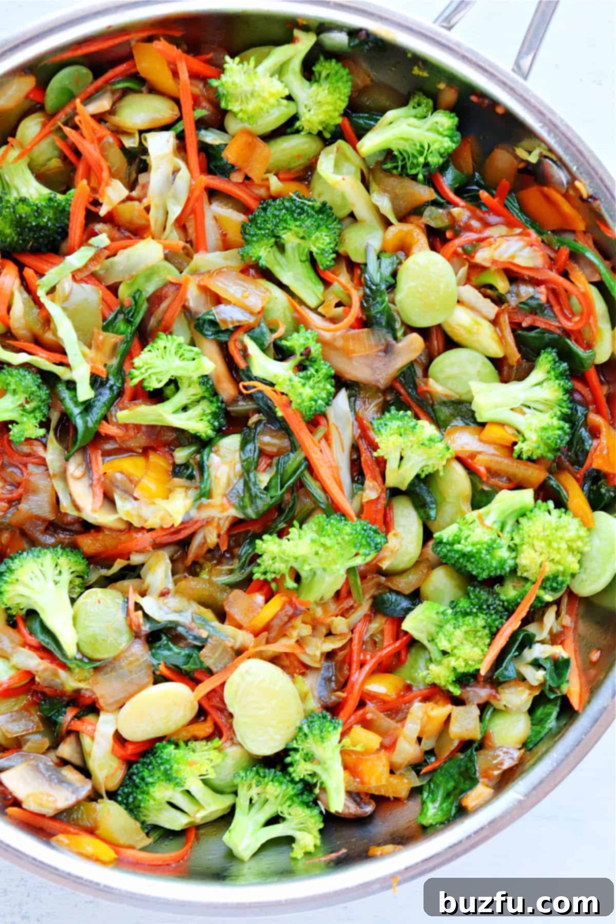 A close-up view of the perfectly cooked, glossy vegetables in a pan, coated in stir-fry sauce.