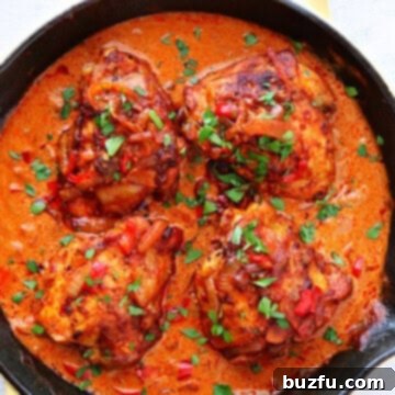 Chicken in paprika sauce in a skillet, showcasing the rich color and creamy texture of the paprikash.
