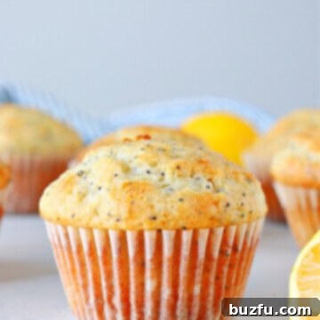 Lemon muffin with poppy seeds on a board.